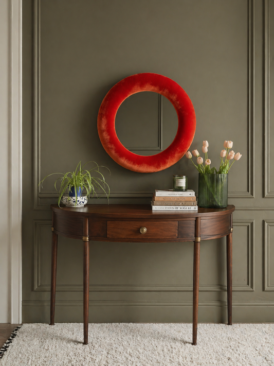 Terracotta rust velvet mirror styled above console in warm considered living space