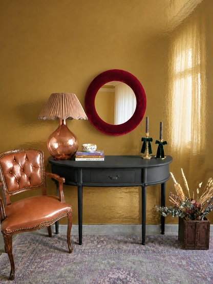 Deep wine velvet mirror styled in eclectic vintage interior with brass and candlelight